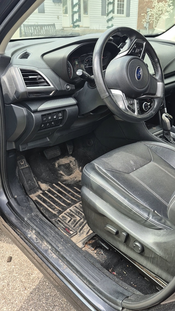 Car interior before detailing — dusty dashboard and dirty seats in dim lighting